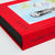 A close-up of a hardcover book with a bright red cloth-embossed spine and cover, featuring the title 'HIDDEN PICTURES' in black lettering and a partially visible illustrated cover scene.